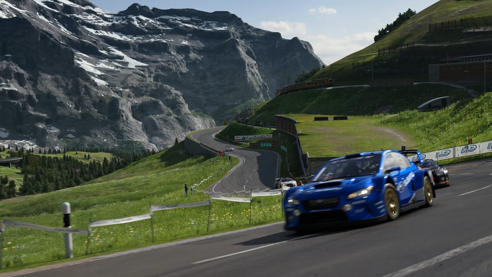 A blue Subaru at speed on the Eiger Nordwand course, Alps behind