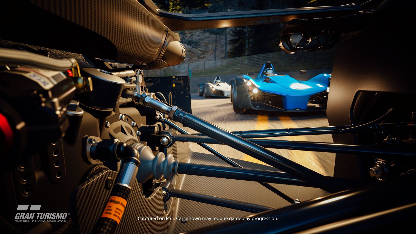 Close-up of an open-wheel car's engine and suspension in the garage